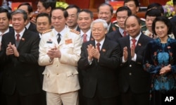 Newly re-elected Vietnam Communist Party General Secretary Nguyen Phu Trong, center front, flanked by Politburo members Tran Dai Quang, second left, Nguyen Xuan Phuc, second right, and Nguyen Thi Kim Ngan, right, at the closing ceremony in Hanoi, Jan. 28, 2016.