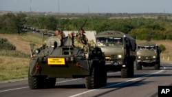 Russian military vehicles maneuver on a road 9 miles from the Ukrainian border in the Rostov-on-Don region, Russia, Aug. 15, 2014. (AP Photo/Pavel Golovkin)