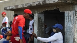 Cuban former baseball player Lazaro de la Torre, right, gives advice to a player after a game in Havana, Oct. 7, 2021. This year a record number of Cuban baseball players have defected abroad, while the island suffers its worst economic crisis in 30 years.