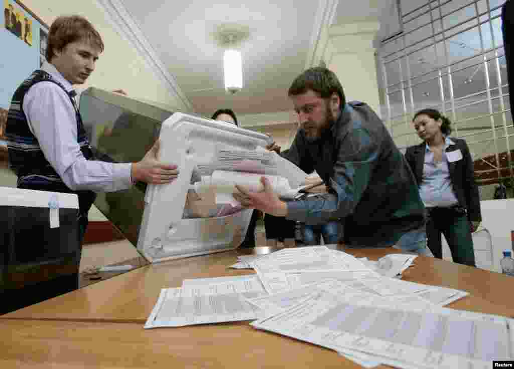 Nhân viên bầu cử đổ phiếu ra đếm sau khi phòng phiếu đóng cửa hôm 8/9. 