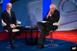 Democratic presidential candidate Senator Bernie Sanders listens to a question from the audience alongside host Anderson Cooper during a Democratic primary town hall sponsored by CNN, in Derry, N.H., Feb. 3, 2016.