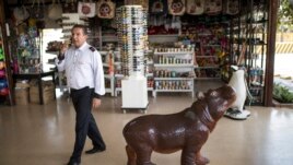 A bus driver walks at a souvenir shop near Hacienda Napoles Park in Puerto Triunfo, Colombia, Tuesday, Feb. 11, 2020. (AP Photo/Ivan Valencia)