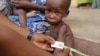 Bác sĩ chăm sóc cho một em bé bị suy dinh dưỡng tại trại tị nạn ở Yola, Nigeria.