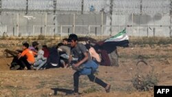 Seorang remaja Palestina berlari dalam aksi protes di perbatasan Gaza, Israel, Jumat (10/5). 