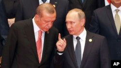 FILE - Russian President Vladimir Putin, right, and Turkish President Recep Tayyip Erdogan chat during a group photo session for the G-20 Summit at the Hangzhou International Expo Center in Hangzhou in eastern China's Zhejiang province, Sept. 4, 2016.