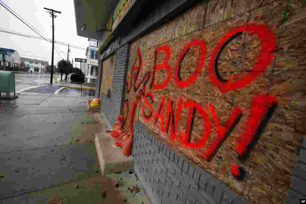 The boarded up windows on a store front in Margate N.J., read "Boo Sandy!", as the area prepares for the arrival of the superstorm, Sunday, Oct. 28, 2012.