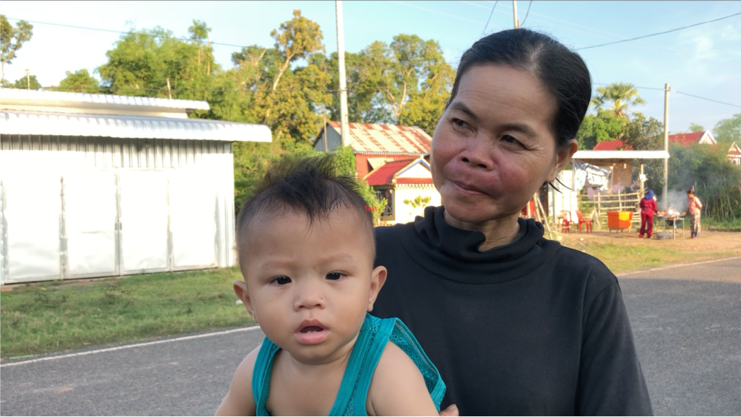 អ្នកស្រី ស៊ឹម ឡាត់ វ័យ ៤០ឆ្នាំ និងក្មួយប្រុស អាយុ៥ខែ ដែលអ្នកស្រីត្រូវជួយមើលថែជំនួសម្តាយ របស់គេ ដែលត្រូវទៅធ្វើការ។ នៅភូមិស្នៀង ឃុំស្វាយតាយាន ខេត្តស្វាយរៀង នៅថ្ងៃទី១១ ខែតុលា ឆ្នាំ២០១៩។ (ខាន់ សុគុំមនោ/VOA)
