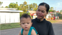 Sim Lat, 40, carries her nephew Ham Ya Oudom on a walk while waiting for his mom to come back from work, at Svay Ta Yean commune, Svay Rieng province, Cambodia, Oct. 11, 2019. (Khan Sokummono/VOA Khmer)