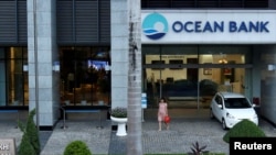  A woman walks out of a branch of Ocean Bank located in the PetroVietnam building in Hanoi, Vietnam, Sept. 1, 2017. 