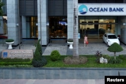A woman walks out of a branch of Ocean Bank located in the PetroVietnam building in Hanoi, Vietnam, Sept. 1, 2017.