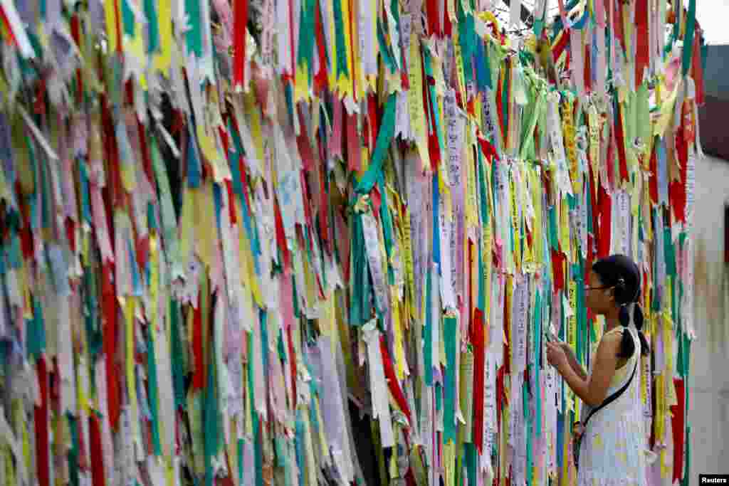 A girl looks at a barbed-wire fence decorated with ribbons bearing messages wishing for the unification between the two Koreas near the demilitarized zone separating the two Koreas in Paju, South Korea.