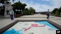 Visitors walk by a map of two Koreas showing North Korea's capital Pyongyang and South Korea's capital Seoul at the Imjingak Pavilion in Paju, near the border with North Korea, South Korea, Sept. 24, 2021.