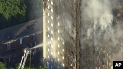 Fotografija načinjena od video snimka na kome se vidi dim kako se uzdže iz stambenog solitera u Londonu, 14. juna 2017.