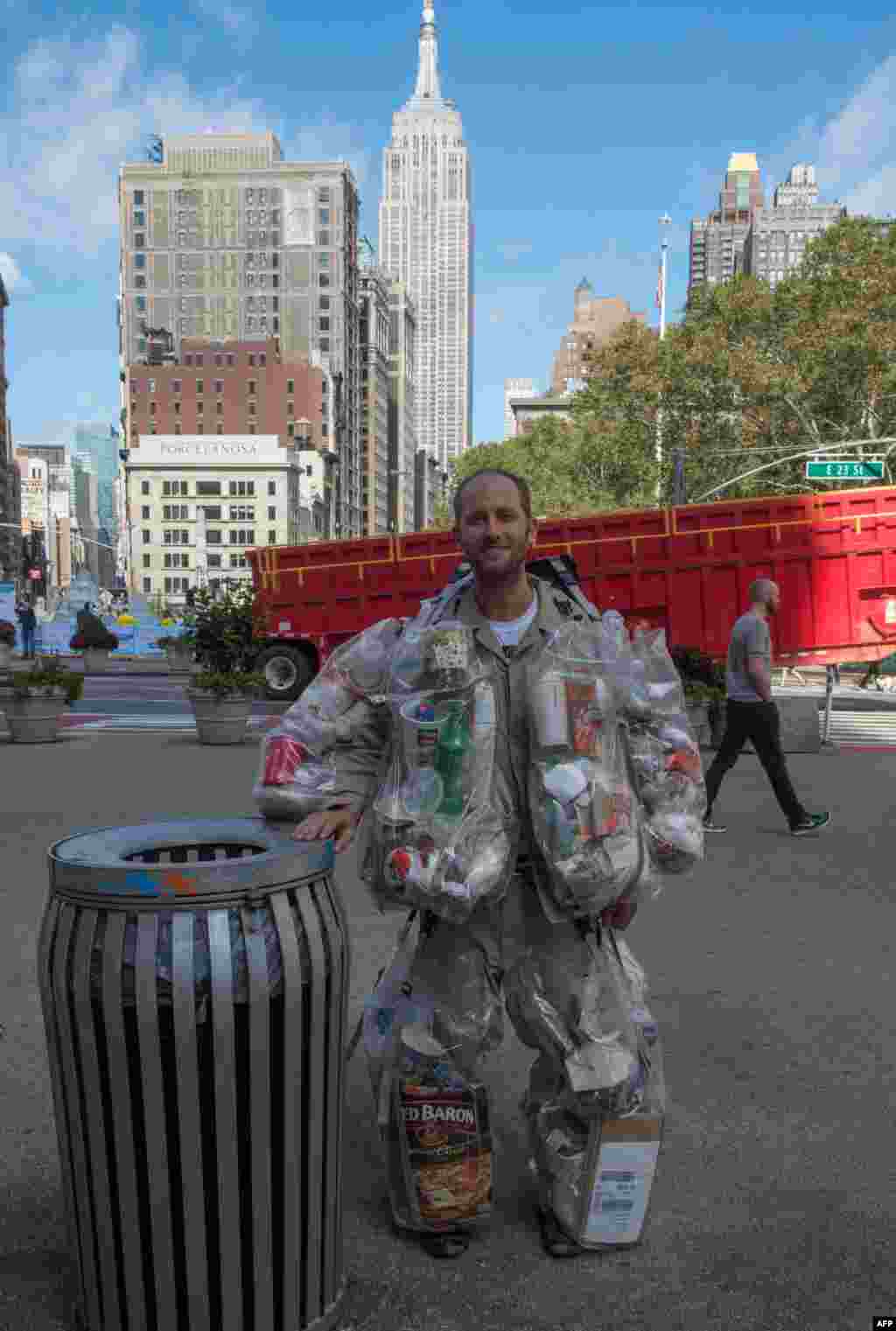 Rob Greenfield, an environmental activist who is spending a month in New York, hangs plastic bags on himself that are full of the trash he has produced.