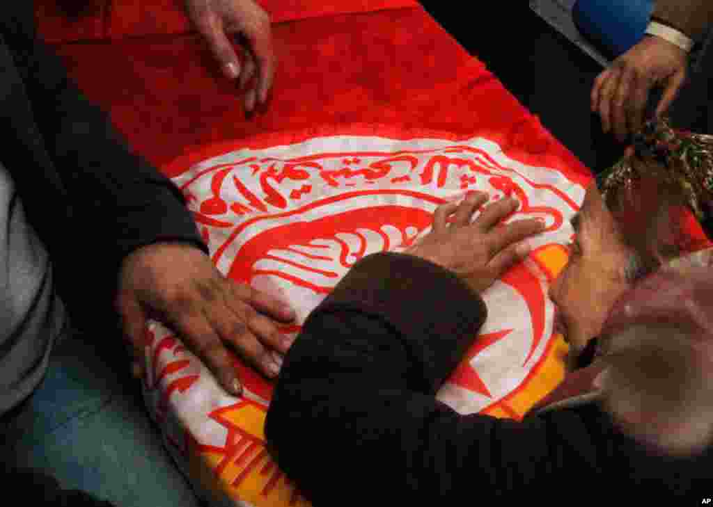 A woman cries over the coffin of opposition leader Chokri Belaid, in Tunis, Feb. 7, 2013.