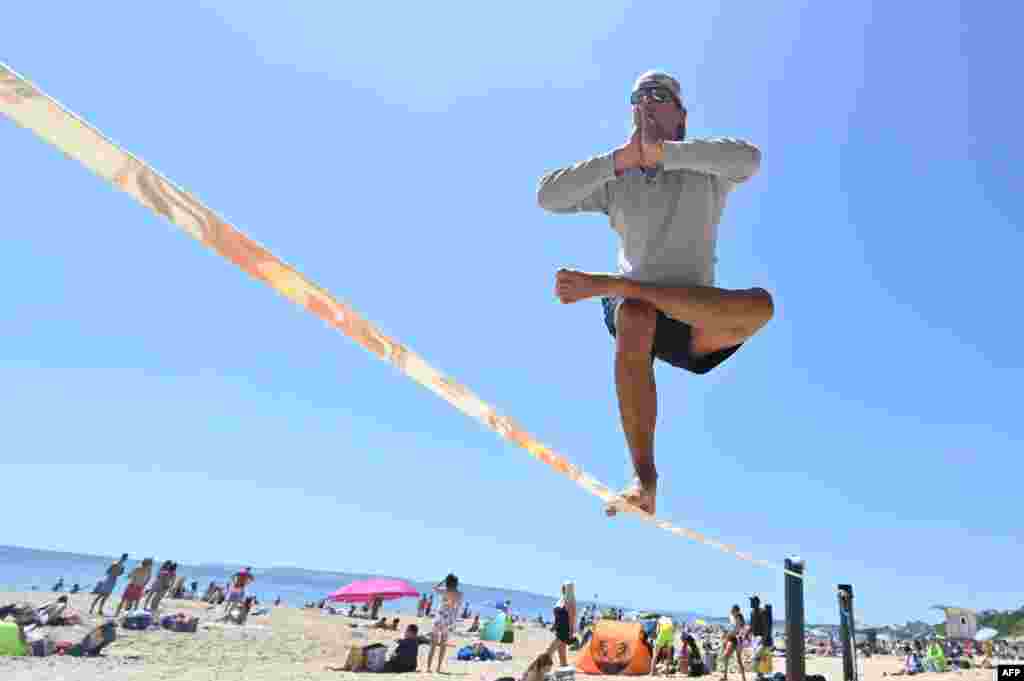 Sandor Nagy practices slacklining at Boscombe Beach in Bournemouth, southern England after some lockdown restrictions put in place to slow the spread of COVID-19 were eased earlier this month.