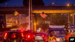 An Ethiopia national flag, left, is seen next to a U.S. flag, center, in a busy street ahead of U.S. President Barack Obama's visit to Addis Ababa, Ethiopia, Saturday, July 25, 2015.