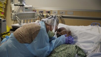 Bà Romelia Navarro, 64, khóc khi ôm chồng, ông Antonio, lần cuối khi ông sắp qua đời vì COVID-19 tại Bệnh viện St. Jude ở Fullerton, bang California 
