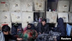 Migrants rest wrapped in blankets inside a derelict customs warehouse in Belgrade, Serbia, Nov. 11, 2016.