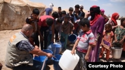 Norwegian Refugee Council staff dispense drinking water to Iraqis at Amariyat Al Fallujah displacement camp. (NRC courtesy photo)