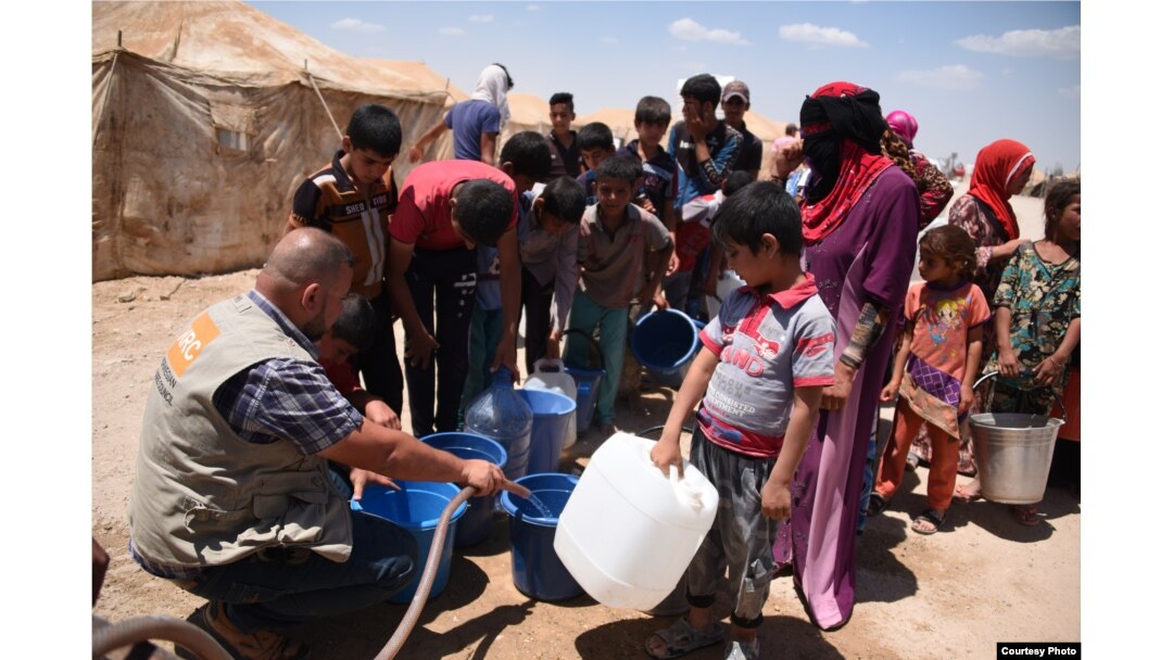 Norwegian Refugee Council staff provide drinking water for Iraqis from Fallujah at Amariyat al-Fallujah displacement camp. Photo: Karl Schembri/NRC