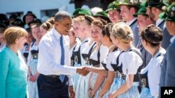 美國總統奧巴馬（左二)和德國總理默克爾(左）與身穿傳統巴伐利亞服裝的觀眾握手。
