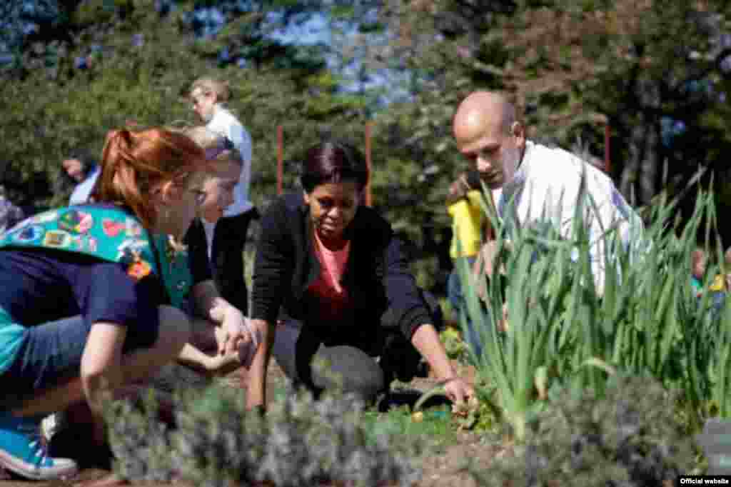 La primera dama Michelle Obama y el asesor para las iniciativas de salud y alimentaci&oacute;n de su oficina, Sam Kass, junto a estudiantes y las Girl Scout de Fairport, Nueva York. (Foto oficial de la Casa Blanca de Sonya N. Hebert).