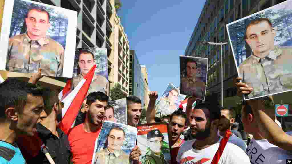 Les familles de Saif Thebian et Mohammed Hussein Yousuf qui ont été enlevé par les combattants de l&rsquo;Etat Islamique et le Front Al-Nusra, brandissent leurs portraits lors d&rsquo;une manifestation à Beirut, Liban. (Le 2 octobre 2014). 