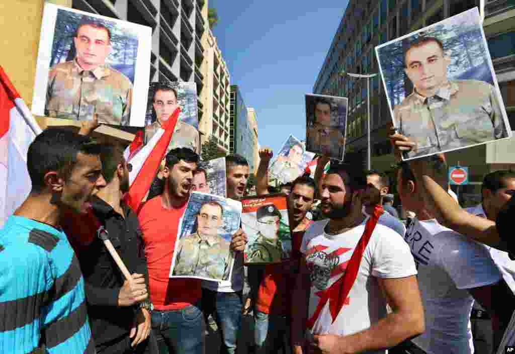 Families of Saif Thebian and Mohammed Hussein Yousuf, who were kidnapped by Islamic State militants and the Al-Nusra front, hold their portraits of during a demonstration in Beirut, Lebanon, Oct. 2, 2014.
