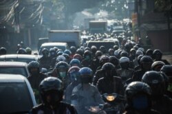 Orang-orang mengendarai sepeda motor pada hari pertama larangan mudik karena pemerintah menghentikan perjalanan laut, darat, udara, dan kereta api dari 6 hingga 17 Mei dalam upaya mencegah penularan COVID dalam skala besar- 19 pandemi di Bandung, Jawa Bar