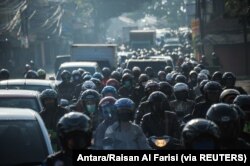 Orang-orang mengendarai sepeda motor di Bandung, Jawa Barat, menjelang idulfitri. (Foto: Antara/Raisan Al Farisi via Reuters)