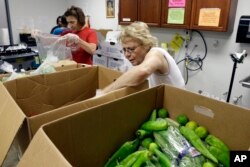 FILE - Volunteers pack food to be distributed at the Catholic Parish Outreach Food Pantry in Raleigh, North Carolina, Sept. 13, 2013.