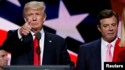 FILE - Republican presidential nominee Donald Trump gives a thumbs up as his campaign manager Paul Manafort looks on during Trump's walk through at the Republican National Convention in Cleveland, July 21, 2016.