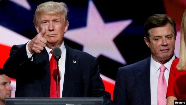 FILE - Republican presidential nominee Donald Trump gives a thumbs up as his campaign manager Paul Manafort looks on during Trump's walk through at the Republican National Convention in Cleveland, July 21, 2016.