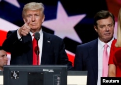 FILE - Republican presidential nominee Donald Trump gives a thumbs up as his campaign manager Paul Manafort looks on during Trump's walk through at the Republican National Convention in Cleveland, July 21, 2016.