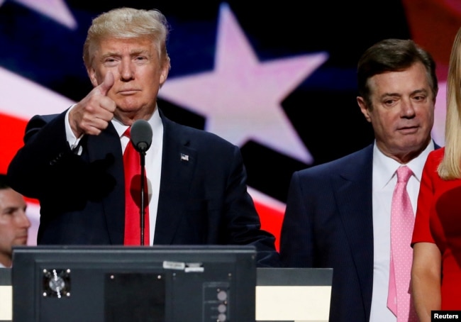 FILE - Republican presidential nominee Donald Trump gives a thumbs up as his campaign manager Paul Manafort looks on during Trump's walk through at the Republican National Convention in Cleveland, July 21, 2016.