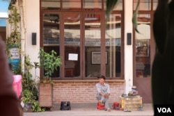 A cobbler looks for a customer while sitting patiently on an empty street in Siem Reap, Cambodia, May 11, 2020. (Phorn Bopha/VOA Khmer)