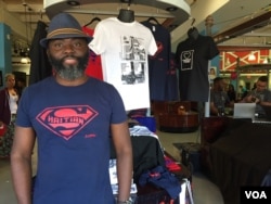 Haitian-American vendor Roe Michel sells inspirational t-shirts with empowering messages at the Caribbean Marketplace. He is wearing his best-seller, the Super Haitian t-shirt in Little Haiti, Miami, Florida. (Photo: S. Lemaire / VOA)
