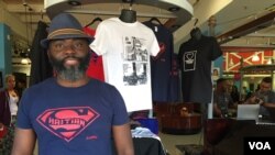 Haitian-American vendor Roe Michel sells inspirational t-shirts with empowering messages at the Caribbean Marketplace. He is wearing his best-seller, the Super Haitian t-shirt in Little Haiti, Miami, Florida. (Photo: S. Lemaire / VOA)