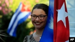 17일 칠레 산티아고 쿠바 대사관 앞에서 한 여성이 쿠바 국기를 들고 미국과 국교정상화를 축하하고 있다.