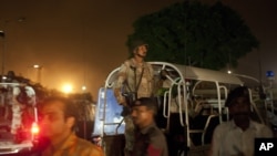 Pakistani security troops rush to Karachi airport terminal following attacks by unknown gunmen on Sunday night, June 8, 2014, in Pakistan.