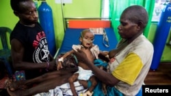 FILE - Family members helps to care for a sick child being treated at the Regional General Hospital (RSUD) in Agats, Asmat District, in the remote region of Papua, Jan. 22, 2018 in this photo taken by Antara Foto. 