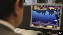 Oscar Bernarl, economist at ING bank, checks the status of the financial markets on his desktop in his office in Brussels, August 8, 2011