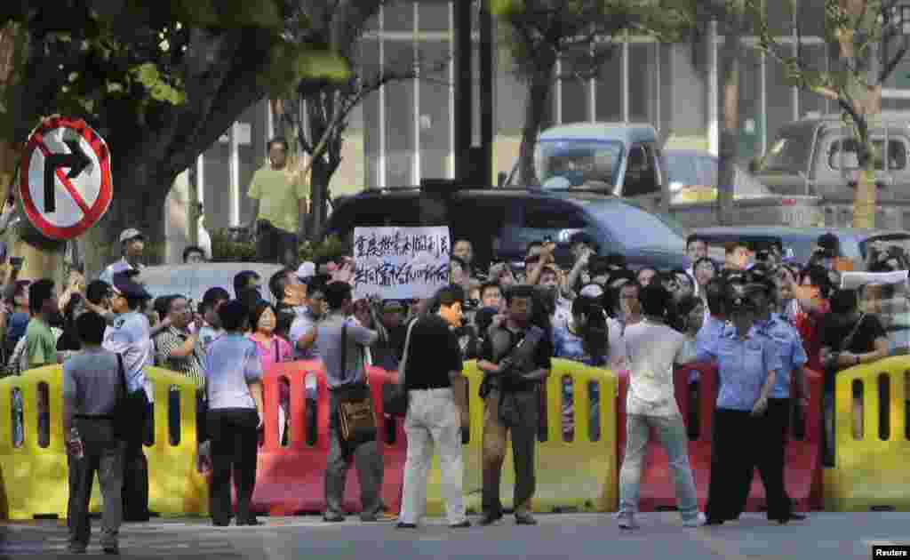 在薄熙來受審的濟南中級人民法院附近，薄熙來的支持者在警方封鎖線後集會。（2013年8月22日）