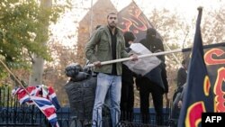 Протестувальнки поруч із зірваним британським флагом, у посольстві Британії в Тегерані.