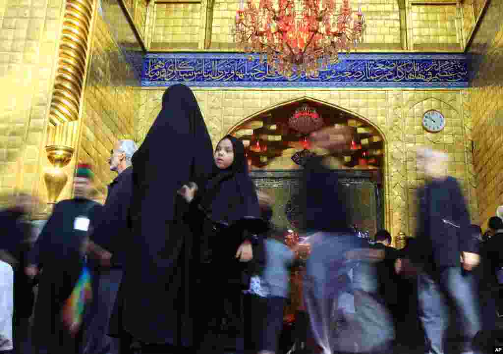 Umat Syiah memasuki tempat suci Imam Abbas, adik Imam Hussein, dalam perayaan Ashura di Karbala, Irak (12/11). (AP/Hadi Mizban)