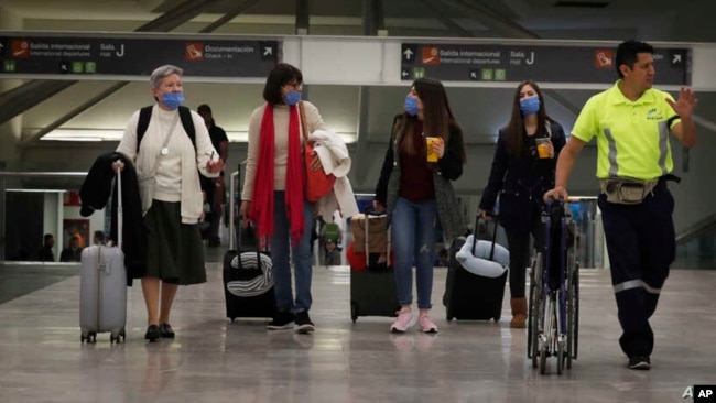 在墨西哥城机场，人们带着口罩防备新冠病毒疫情的扩散。