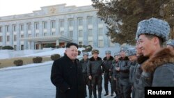 Pemimpin Korea Utara Kim Jong-un (tengah) dalam sesi foto bersama para pilot tempur di Pyongyang dalam foto yang dirilis kantor berita KCNA (2/2).