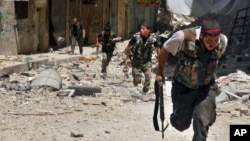 This Tuesday, July 9, 2013 citizen journalism image provided by Aleppo Media Center AMC, which has been authenticated based on its contents and other AP reporting, shows Syrian rebels running during heavy clashes with Syrian soldiers loyal to Syrian Presi