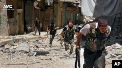This Tuesday, July 9, 2013 citizen journalism image provided by Aleppo Media Center AMC, which has been authenticated based on its contents and other AP reporting, shows Syrian rebels running during heavy clashes with Syrian troops.